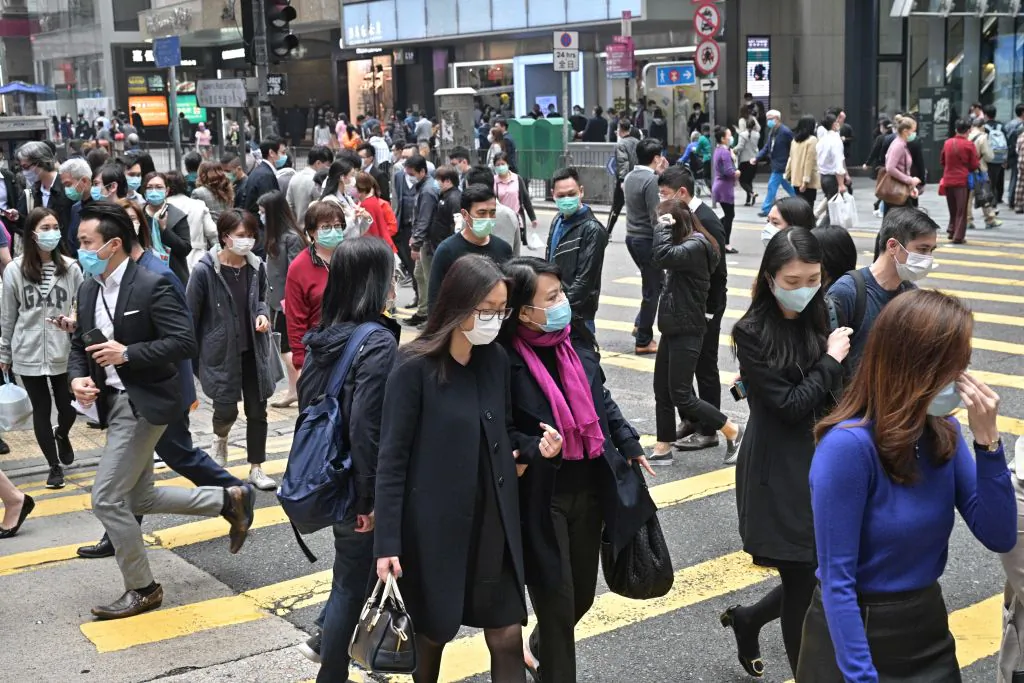 Pedestrians wearing face masks in Hong Kong on March 12, 2020. (Antony Wallace/AFP via Getty Images)