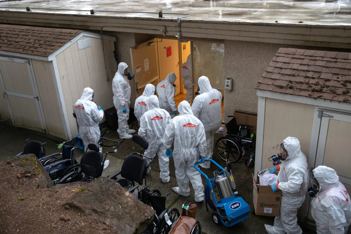 A cleaning crew wearing protective clothing enters a long-term care facility where a COVID-19 outbreak occurred n Kirkland, Washington, on March 12, 2020. (John Moore/Getty Images)