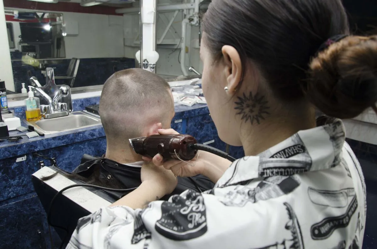 A haircut is given in the barbershop aboard the submarine tender USS Frank Cable (AS 40), on Oct. 17, 2019. (U.S. Navy/Seaman Heather C. Wamsley/Released)