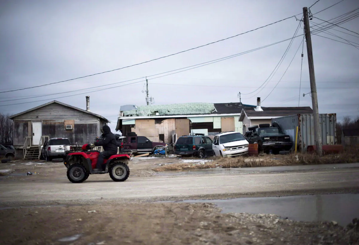 A man rides his ATV in the northern Ontario First Nations reserve in Attawapiskat, Ont., in a file photo. (The Canadian Press/Nathan Denette)