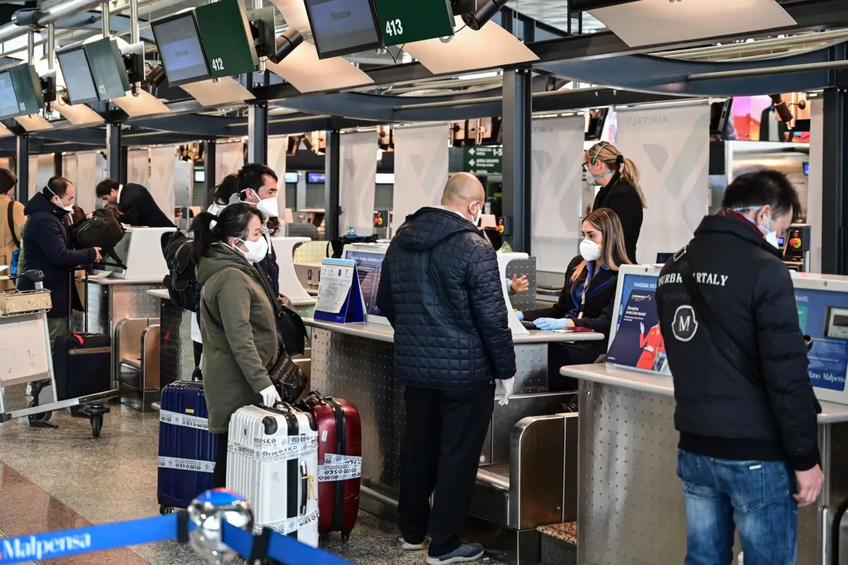 Passengers wearing a protective mask check in for a flight to Moscow at Milan-Malpensa airport in Ferno, northwest of Milan, in one of Italy's quarantine red zones on March 9, 2020. (Miguel Medina/AFP  via Getty Images)