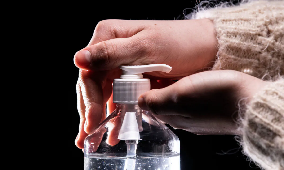 A person takes from a bottle of hydroalcoholic hand sanitizer in Paris on March 5, 2020. (Lionel Bonaventure/AFP via Getty Images)