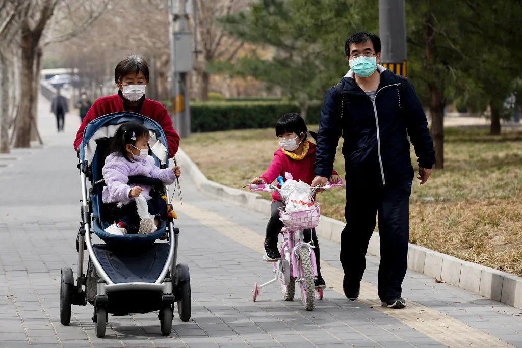 A Chinese family wearing a protective facemask at a park in Beijing, China, on March 19, 2020. (Lintao Zhang/Getty Images)