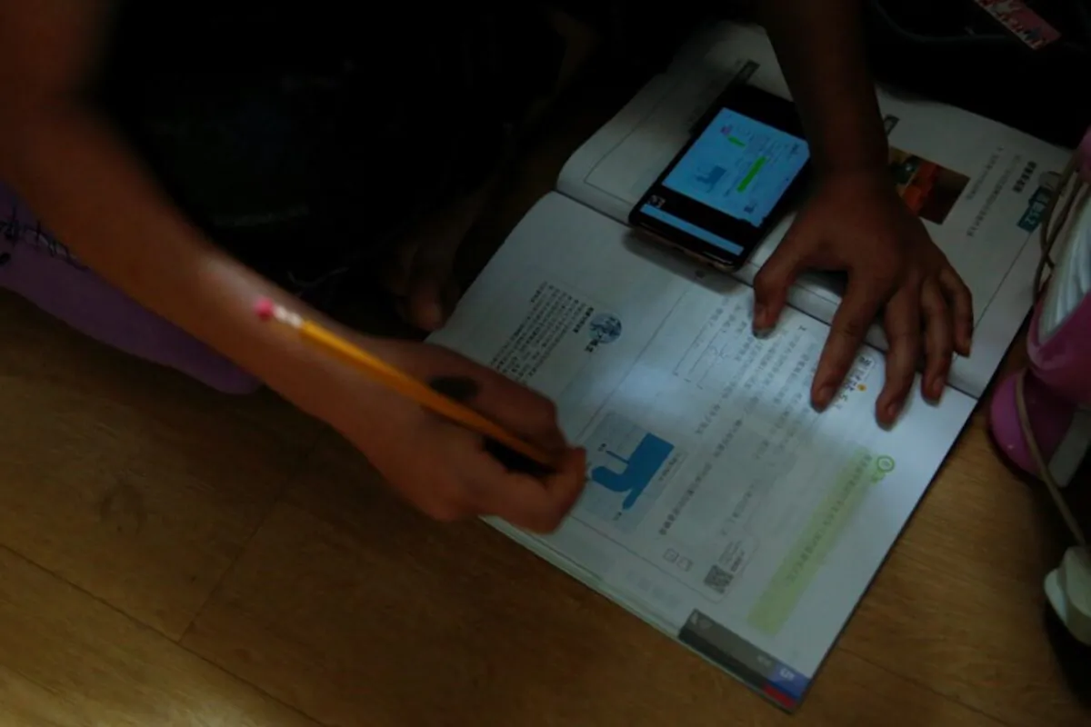 Secondary school student Wendy attends an online class with a smartphone at home during the novel coronavirus disease (COVID-19) outbreak, in Hong Kong, China, on March 16, 2020. (Tyrone Siu/Reuters)