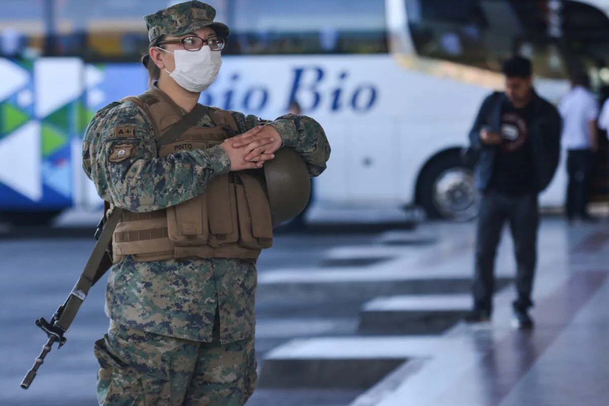 A Chilean soldier wears a protective mask as they stand guard inside a bus station in Concepcion, Chile, on March 19, 2020. (Guillermo Salgado/AFP via Getty Images)