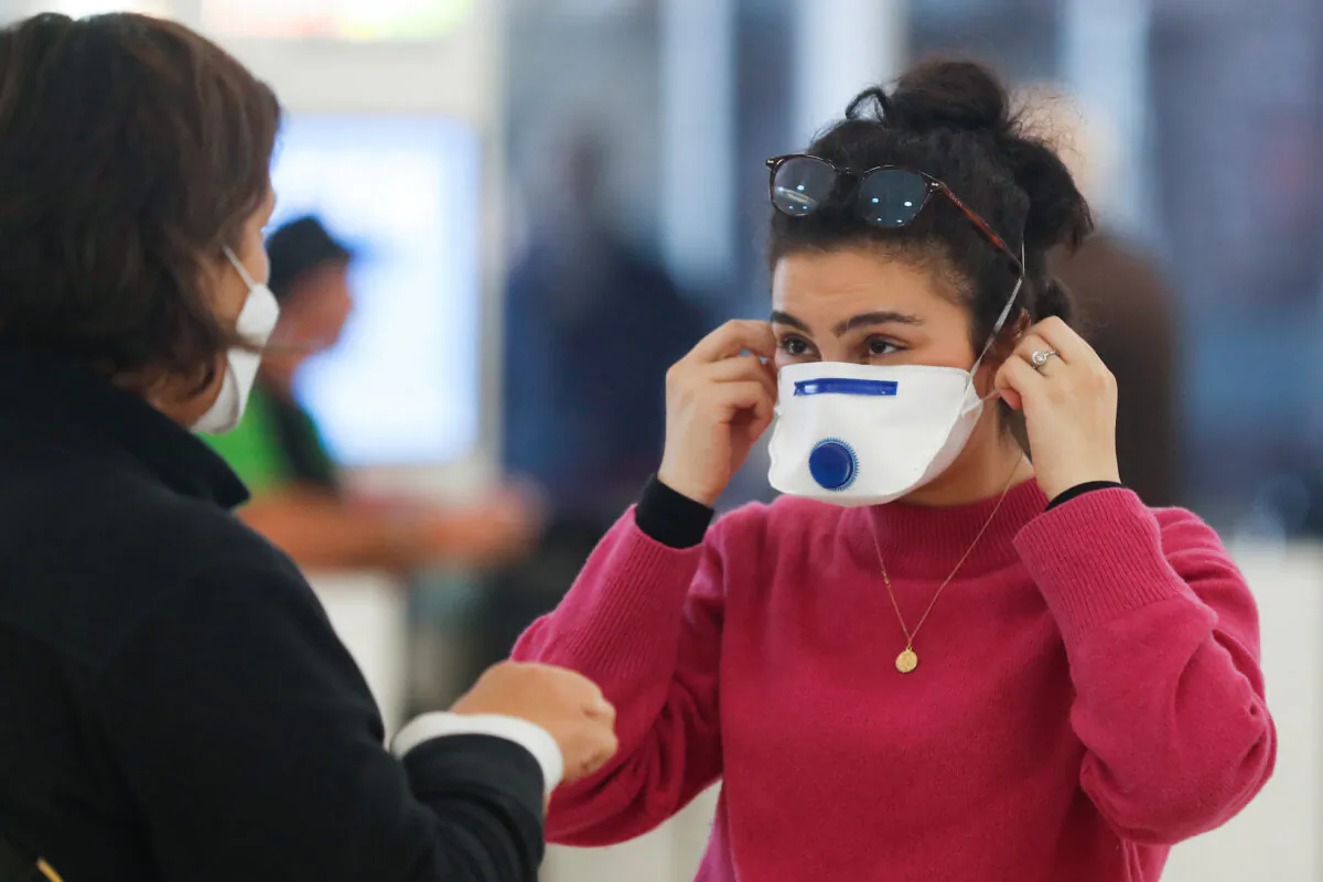A passenger at Sydney airport covers her face with a mask in Sydney, Australia on March 16, 2020. (Brendon Thorne/Getty Images)