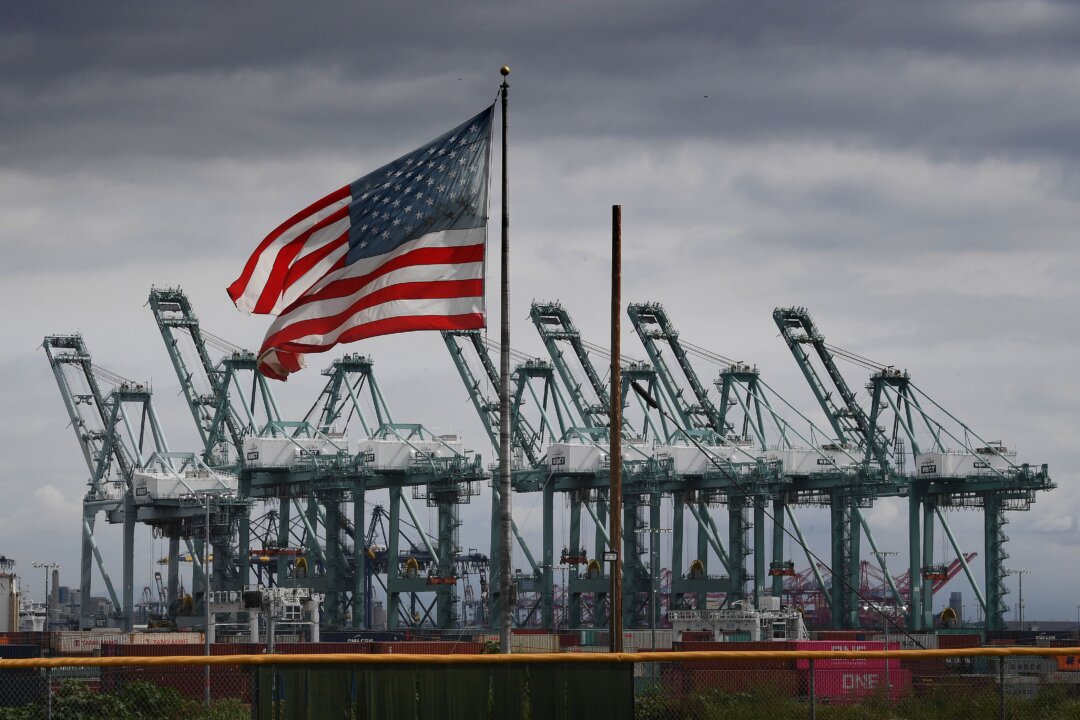 The U.S. flag flies over shipping cranes and containers after a report said the United States and China are close to reaching a major trade deal that would see both sides lower some of the tariffs imposed during an often-bitter trade war, in Long Beach, Calif., on March 4, 2019. (Mark Ralston/AFP via Getty Images)
