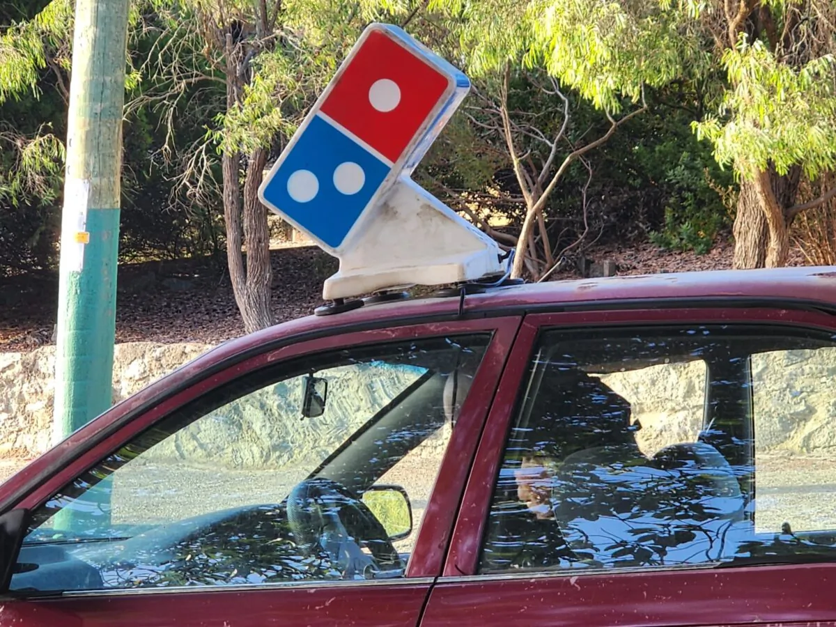 A Domino's employee sits in her car after delivering pizza in Albany, Western Australia, on Feb. 21, 2024. (Susan Mortimer/The Epoch Times)