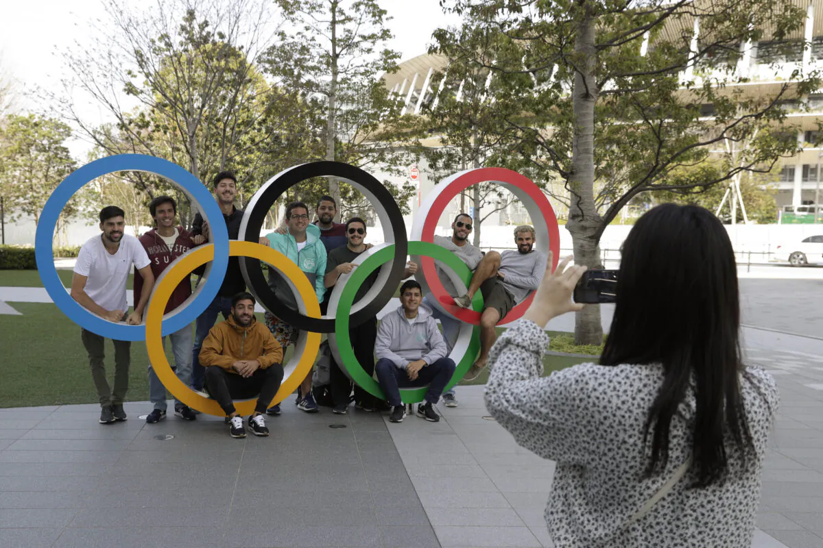 A group of students from Uruguay pose for a souvenir picture on the Olympic Rings set outside the Olympic Stadium in Tokyo, on  March 21, 2020. (Gregorio Borgia/AP Photo)