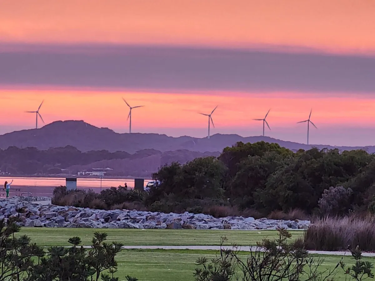 Wind turbines are seen on the horizon at sunset in Albany, Western Australia, on May 19, 2024. (Susan Mortimer/The Epoch Times)