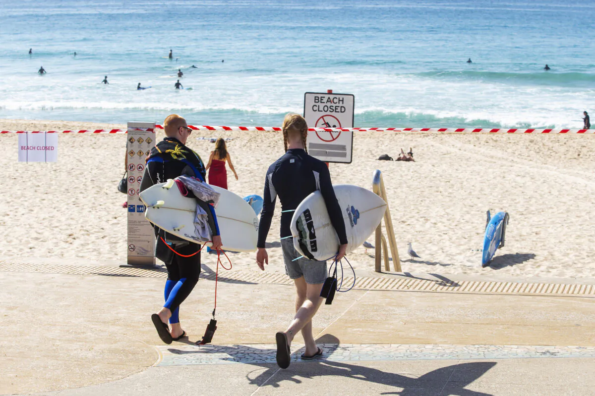 People are seen walking towards tape cordoning off Maroubra Beach as all of Sydney’s eastern suburbs beaches are closed in Sydney, Australia, on March 22, 2020. (Jenny Evans/Getty Images)