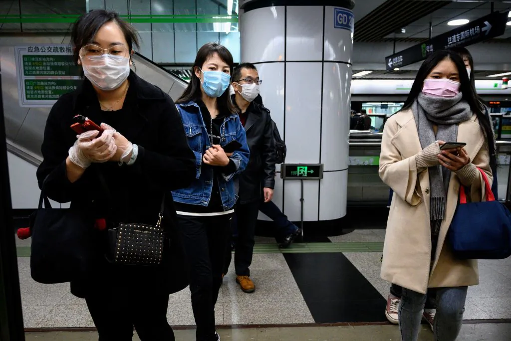 People wearing face masks wait for a train at a subway station in Shanghai on March 23, 2020. (Noel Celis/AFP via Getty Images)