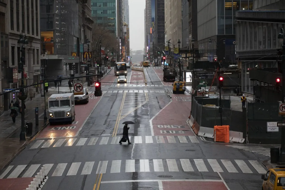 A commuter crosses 42nd Street in front of Grand Central Terminal during morning rush hour in New York on March 23, 2020. (Mark Lennihan/AP Photo)