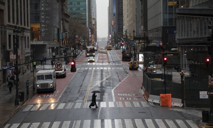 A commuter crosses 42nd Street in front of Grand Central Terminal during morning rush hour in New York on March 23, 2020. (Mark Lennihan/AP Photo)