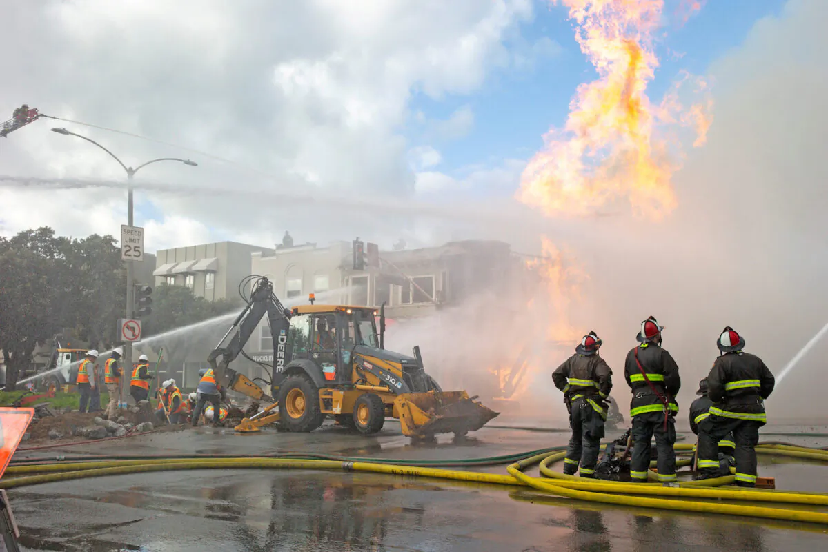Firefighters battle a fire following an explosion at Geary Boulevard and Parker Avenue as PG&E officials dig up the ground to reach the pipe in San Francisco, Calif., on Feb. 6, 2019. (Santiago Mejia/San Francisco Chronicle/Pool via Reuters)