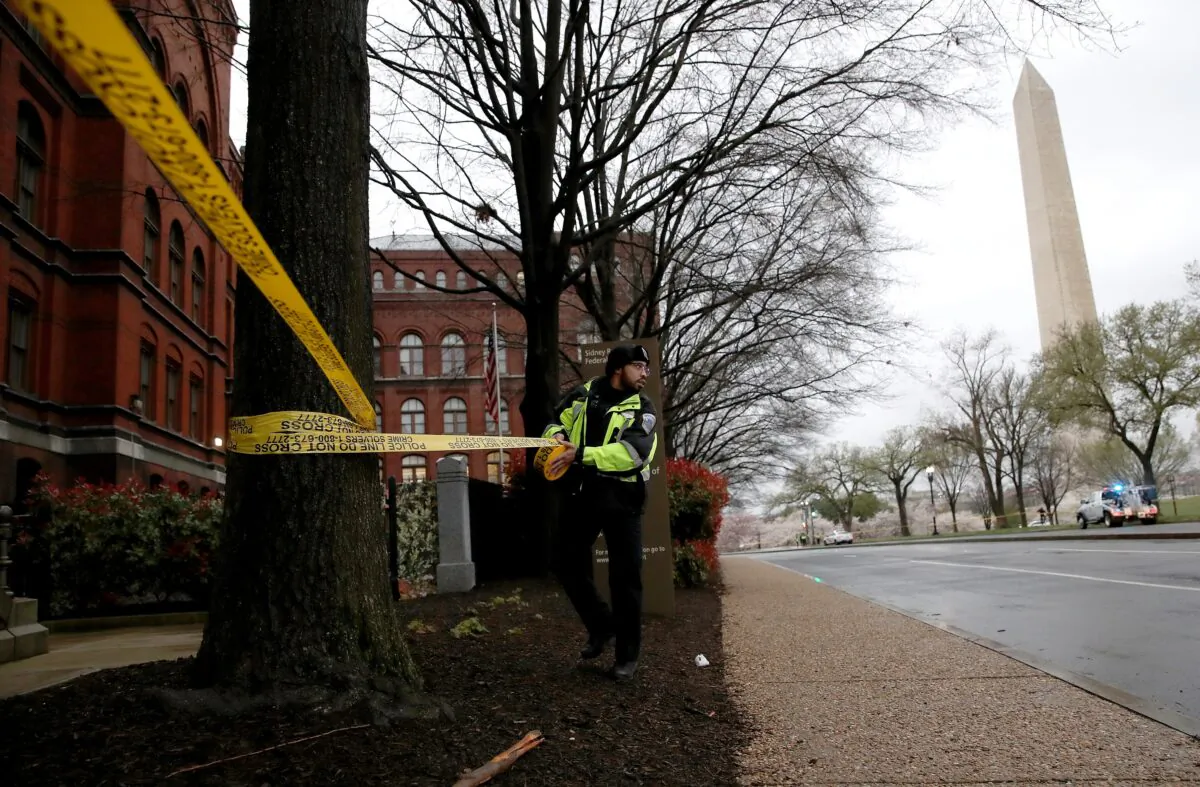 A member of the Metropolitan Police Department closes areas surrounding the Washington Monument and National Mall with police tape due to concerns of the spread of the CCP virus, in Washington on March 23, 2020. (Win McNamee/Getty Images)