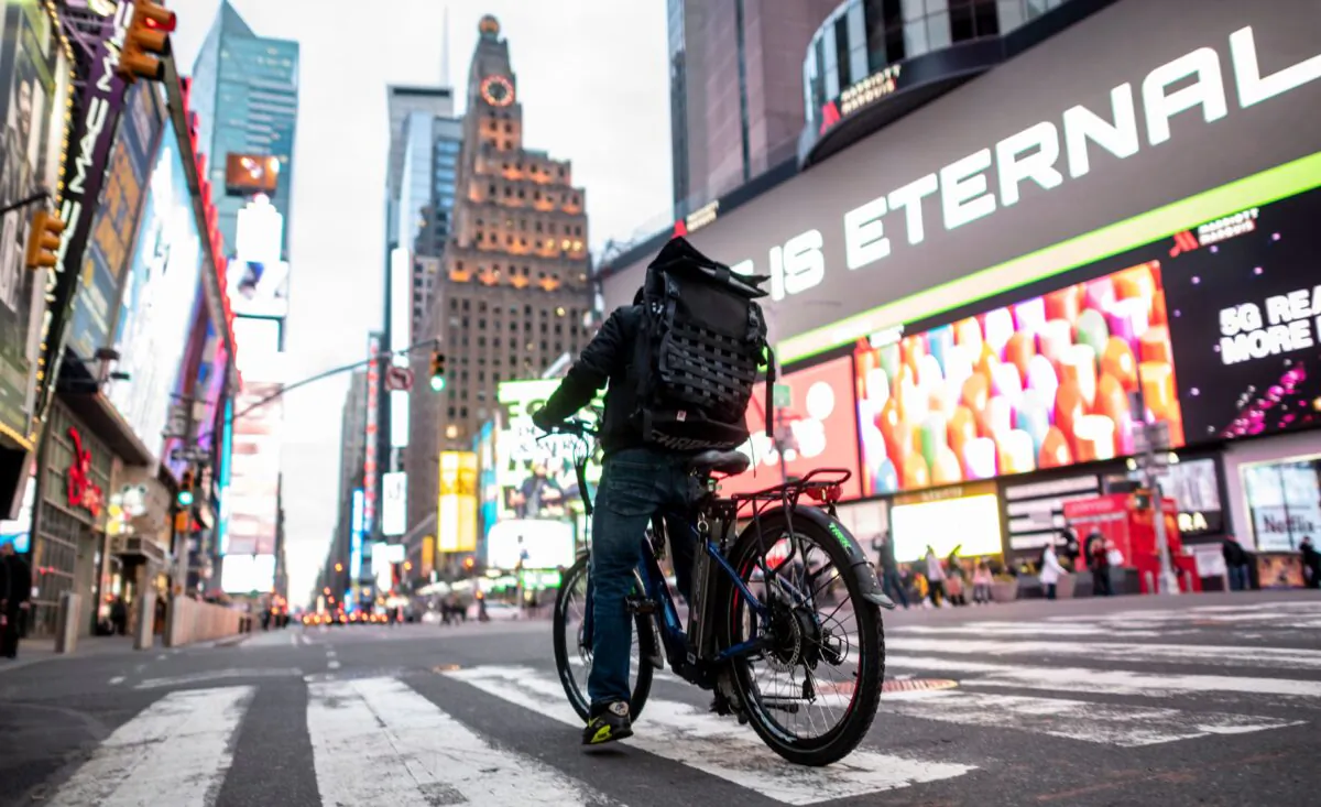 A food delivery man crosses the street in Times Square in Manhattan in a file photo. (Johannes Eisele/AFP via Getty Images)