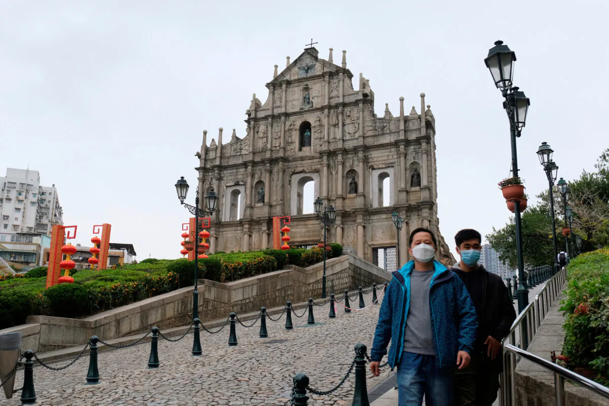 Men wear masks as they walk in front of the Ruins of St. Paulis, following the novel coronavirus outbreak, in Macau, China, on Feb. 5, 2020. (Tyrone Siu/Reuters)