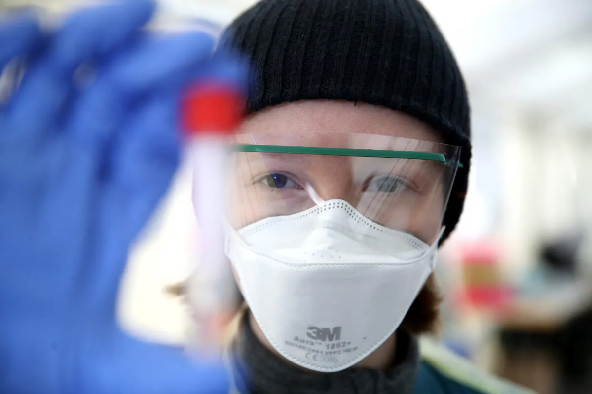 A medical worker holds a vial containing a swab used for CCP virus testing at a new outdoor facility at the Department of Infectious and Tropical Medicine at LMU Universtiy Hospital in Munich, Germany, on March 23, 2020. (Alexander Hassenstein/Getty Images)