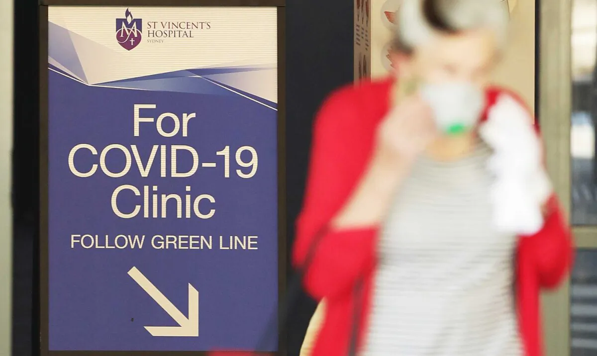 People pass signs for a COVID-19 Clinic as they enter or exit St Vincent's hospital in Sydney, Australia, on March 18, 2020. (Mark Metcalfe/Getty Images)