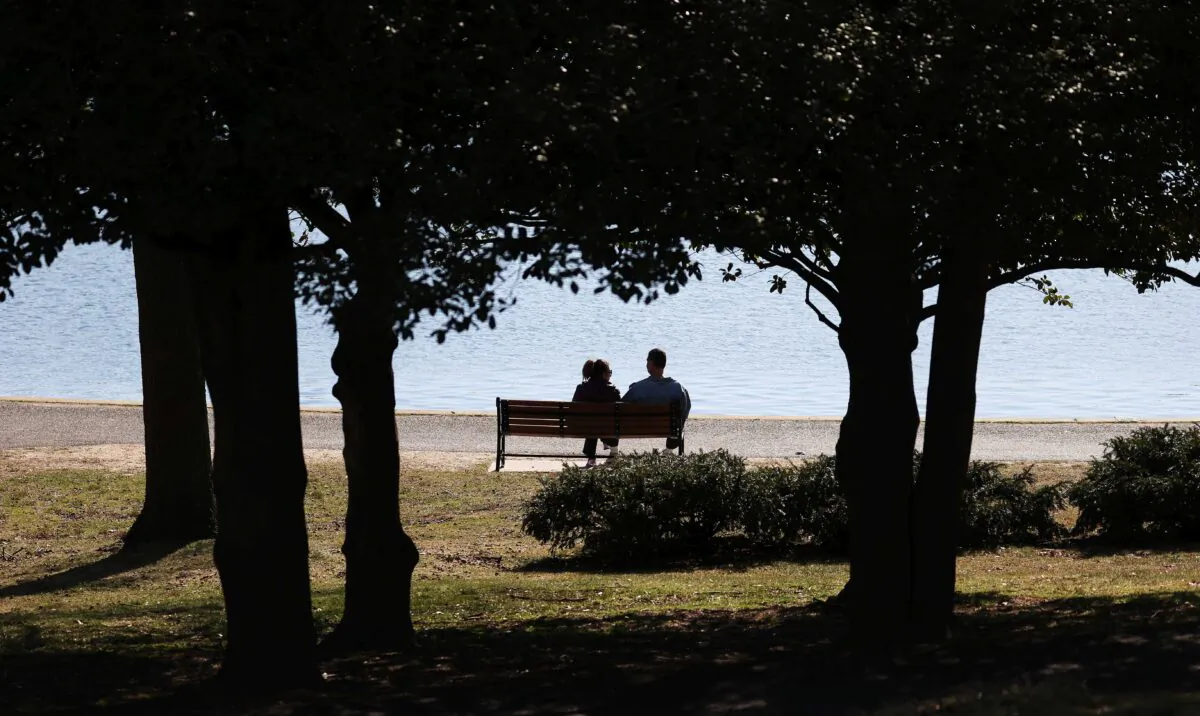 A couple sits on a park bench at Eisenhower Park in East Meadow, N.Y., on March 21, 2020. (Al Bello/Getty Images)