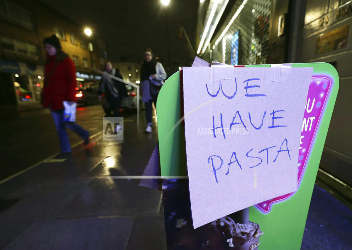 A sign notifies potential customers that pasta is available despite panic buying in the wake of the CCP virus outbreak outside Warwick Way Food & Wine in London on March 19, 2020. (Yui Mok/PA via AP)