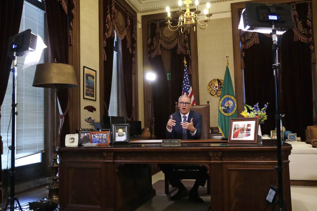 Washington Gov. Jay Inslee practices as he prepares to speak about additional plans to slow the spread of coronavirus before a televised address from his office in Olympia, Washington, on March 23, 2020. (AP Photo/Elaine Thompson)