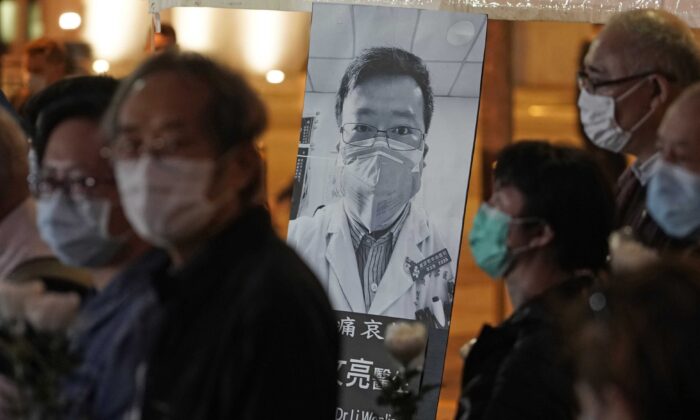 People wearing masks attend a vigil for Chinese doctor Li Wenliang, who was reprimanded for warning about the outbreak of the new coronavirus, in Hong Kong, on Feb. 7, 2020. (Kin Cheung/AP Photo)