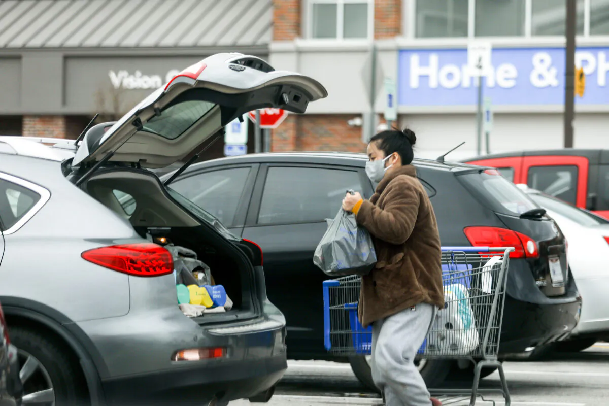 A woman with a face mask loads her groceries in a Walmart carpark in Columbus, Ohio, on March 20, 2020. (Charlotte Cuthbertson/The Epoch Times)