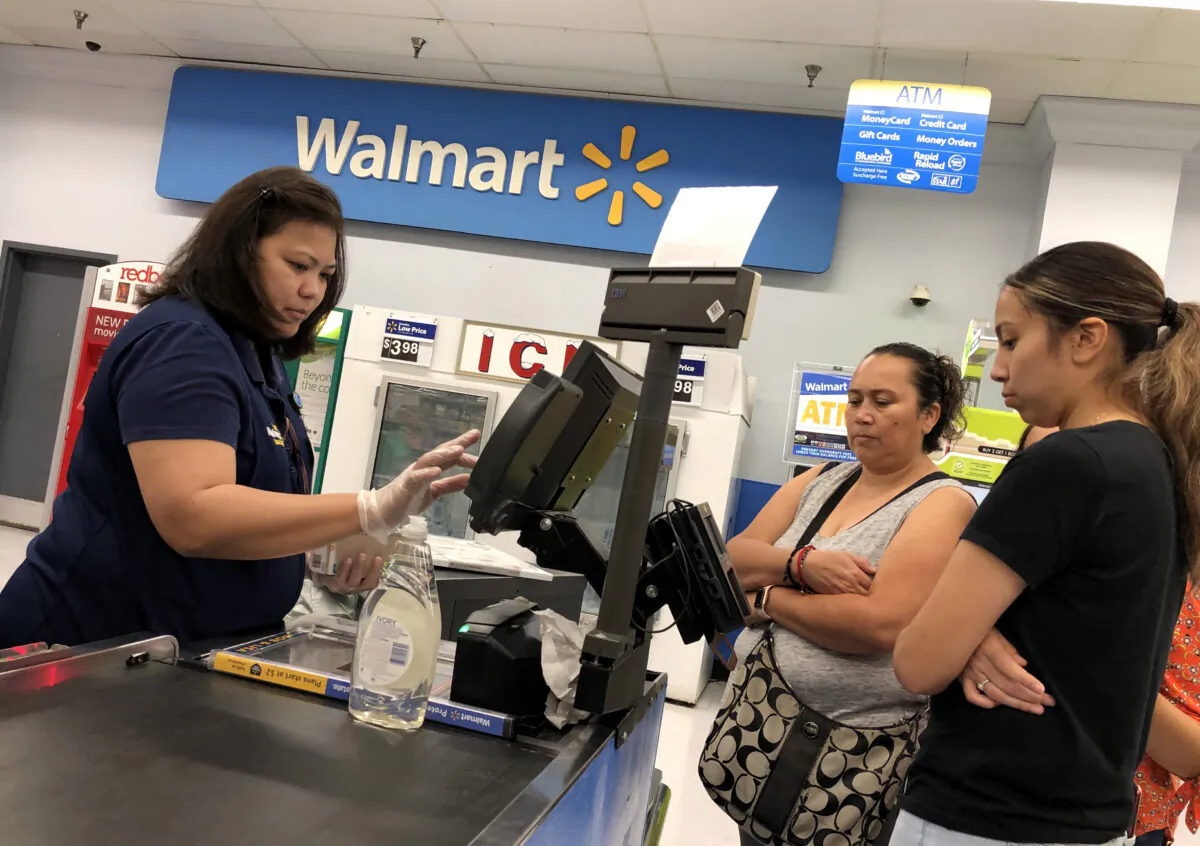 Customers look on as a Walmart cashier rings up their purchases at a Walmart store in California. (Justin Sullivan/Getty Images)
