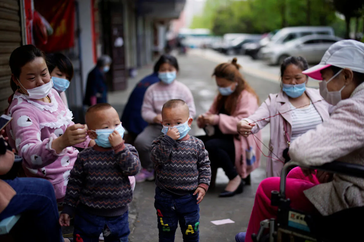 Children and women wearing face masks are seen in Xianning, after the lockdown was eased in Hubei Province, the epicenter of China's coronavirus disease (COVID-19) outbreak, on March 26, 2020. (Aly Song/Reuters)