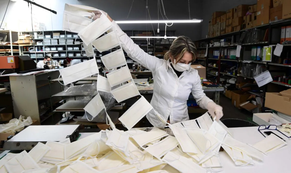 An employee controls surgical masks at a leather workshop turned into a mask factory, close to Vigevano, Lombardy, Italy, on March 19, 2020. (Miguel Medina/AFP via Getty Images)