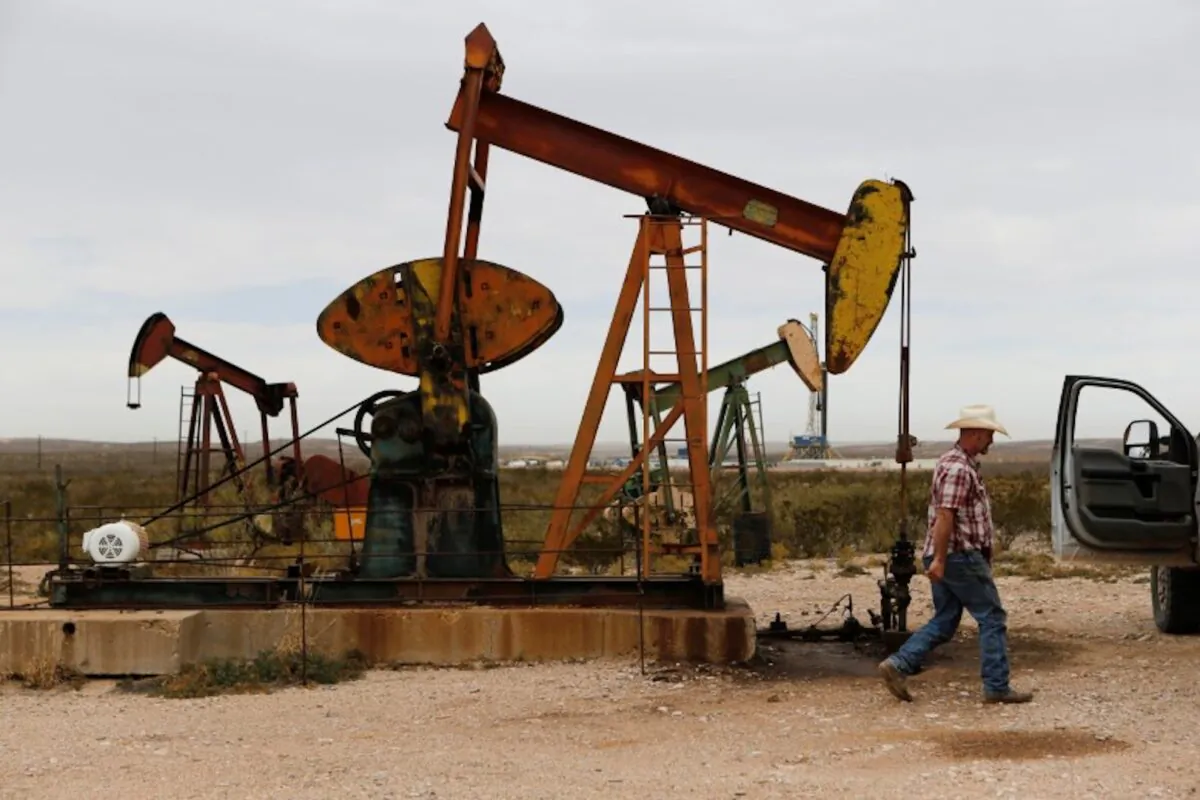 Paul Putnam, 53, a rancher and independent contract pumper walks past a pump jack in Loving County, Texas on Nov. 25, 2019. (Angus Mordant/Reuters)