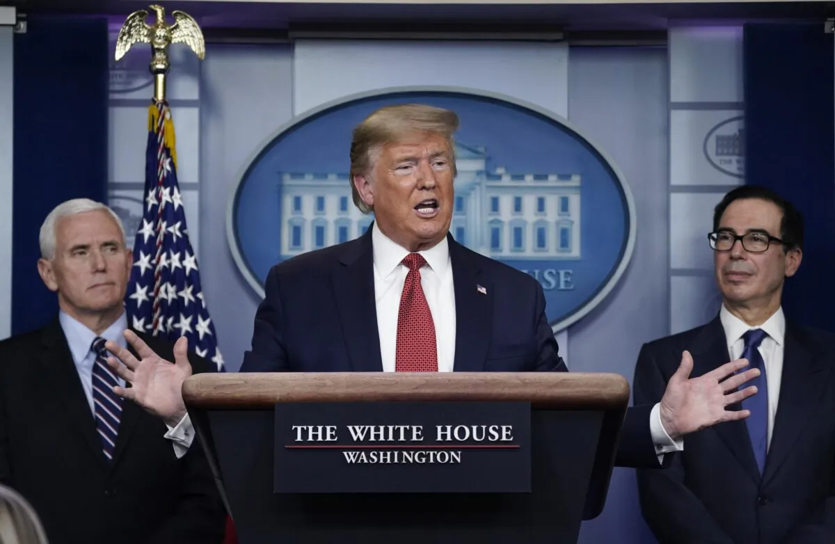 Flanked by Vice President Mike Pence (L) and Treasury Secretary Steven Mnuchin, President Donald Trump  speaks during a briefing on the coronavirus pandemic, in the press briefing room of the White House on March 25, 2020. (Drew Angerer/Getty Images)