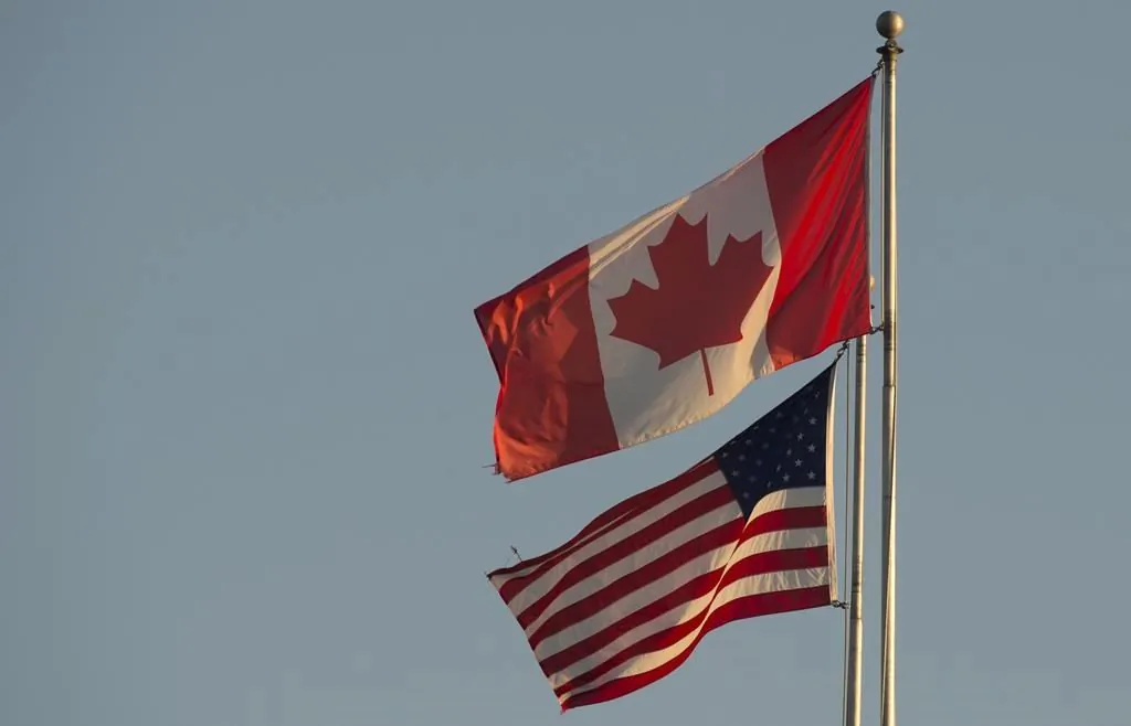 The Canadian and American flags are seen on top of the Peace Arch at the Canada-U.S. border in Surrey, B.C., on March 20, 2020. (Jonathan Hayward/The Canadian Press)