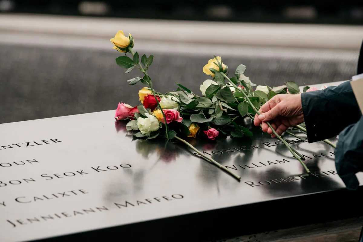 Relatives of the 1993 World Trade Center bombing victims place roses over a plaque etched with victims' names during a ceremony in New York City on Feb. 26, 2020. (Scott Heins/Getty Images)