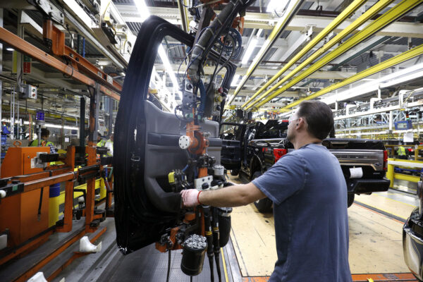 A Ford Motor Company workers works on a Ford F150 truck