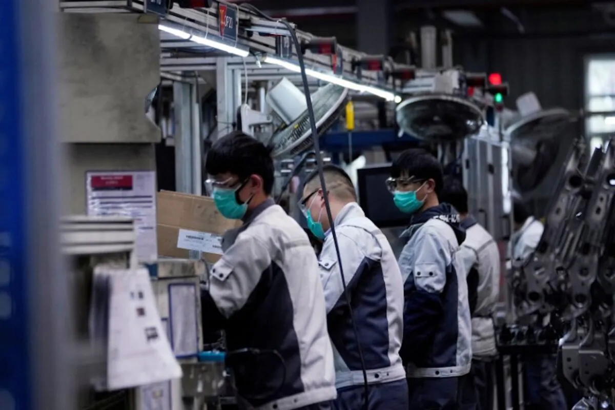 Employees wearing protective face masks work on a car seat assembly line at Yanfeng Adient factory in Shanghai, China, on Feb. 24, 2020. (Aly Song/Reuters)