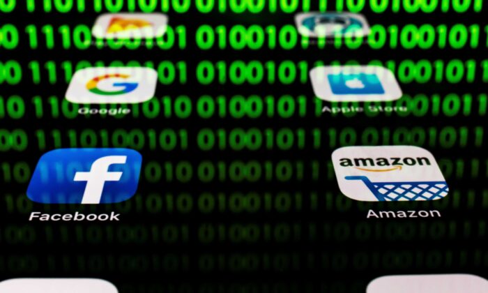 The apps for Google, Amazon, Facebook, Apple with the reflexion of a binary code are displayed on a tablet screen in Paris on April 20, 2018. (Lionel Bonaventure/AFP via Getty Images)