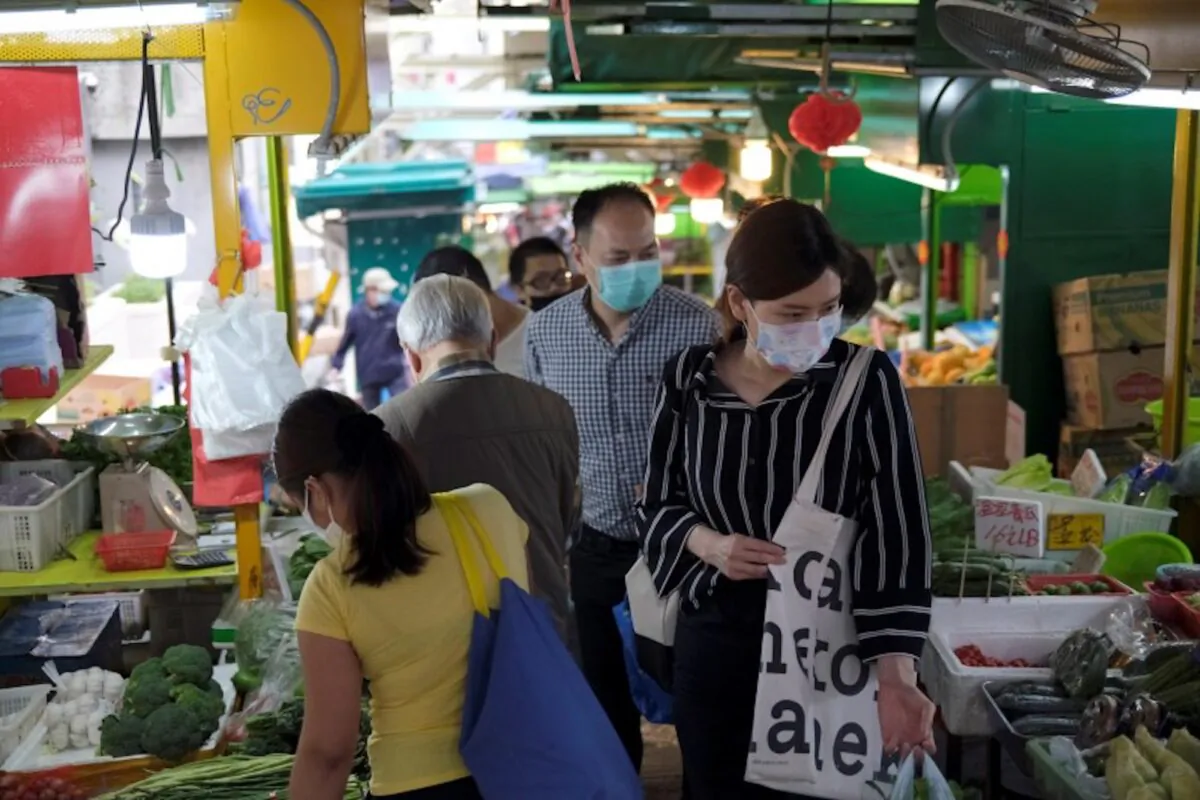 People with protective masks walk at a market at the financial Central District, following the novel coronavirus disease (COVID-19) outbreak, in Hong Kong, China, on March 27, 2020. (Tyrone Siu/Reuters)