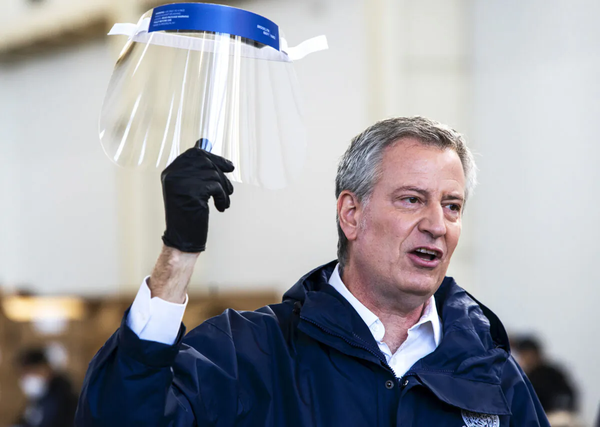 New York City Mayor Bill de Blasio holds a face shield as he speaks to the media during a visit to the Brooklyn Navy Yard where local industrial firms have begun manufacturing Personal Protective Equipment (PPE) in New York CIty on March 26, 2020. (Eduardo Munoz Alvarez/Getty Images)