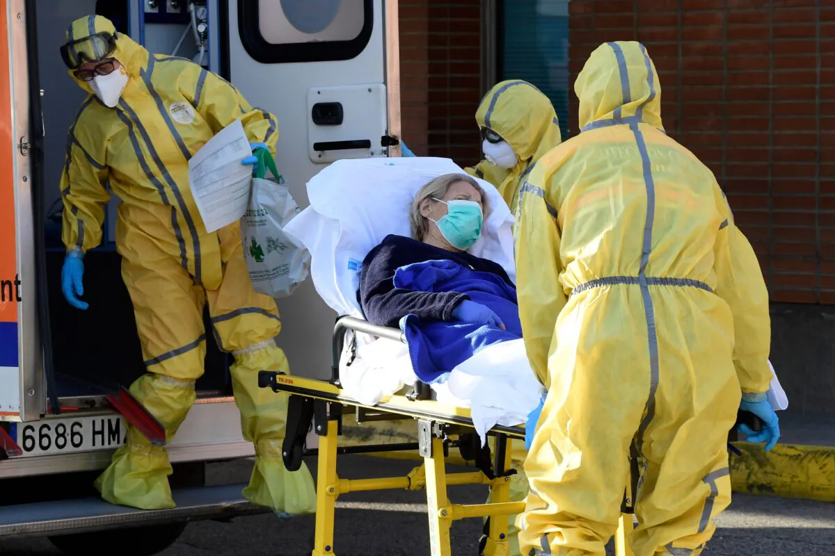 Civil Defence members carry a patient on a stretcher as they arrive at the Severo Ochoa hospital in Leganes, Spain, on March 26, 2020. (Javier Soriano/AFP via Getty Images)