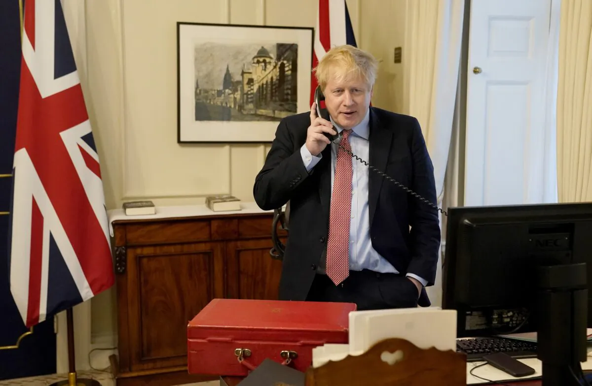 Prime Minister Boris Johnson on the telephone to Queen Elizabeth II for her Weekly Audience during the CCP virus pandemic at 10 Downing Street in London on March 25, 2020. (Andrew Parsons-WPA Pool/Getty Images)