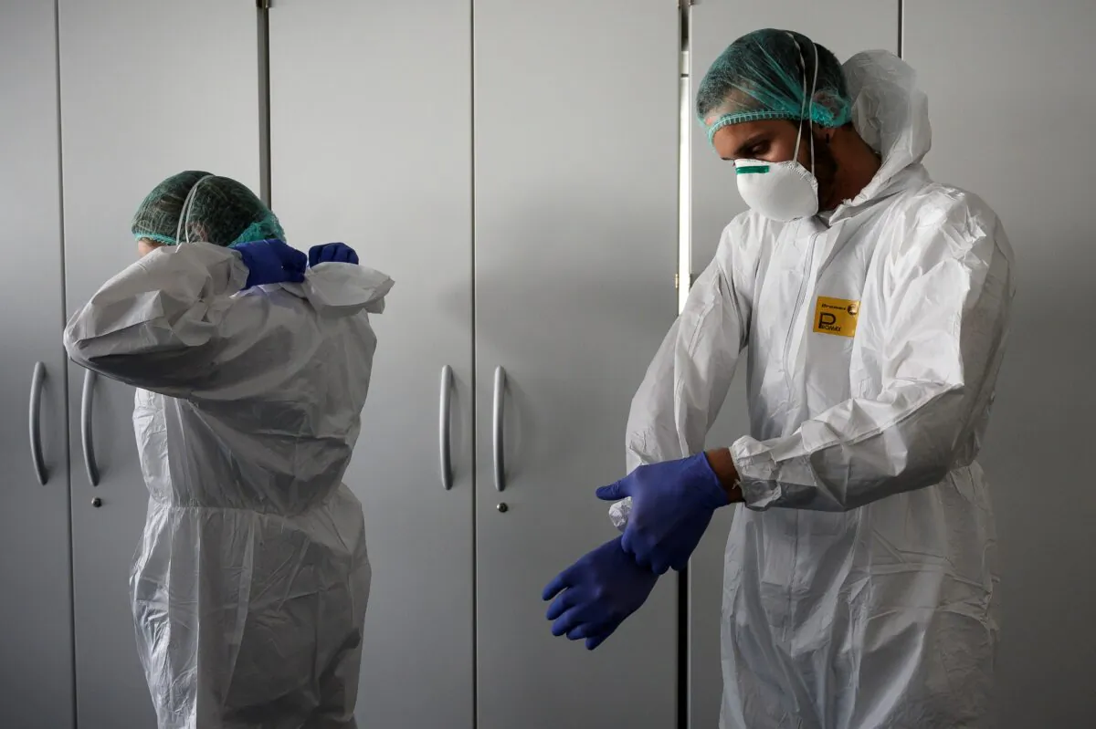 Nurses put on their personal protective equipment before starting to work on the preparation of the intensive care unit in the new COVID-19 Hospital in Verduno, near Alba, Northwestern Italy on March 29, 2020. (Marco Bertorello/AFP via Getty Images)