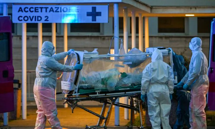 Medical workers take a patient under intensive care into the Columbus Covid 2 temporary hospital, newly built to fight the COVID-19 epidemic, in Rome, Italy, on March 16, 2020. (Andreas Solaro/AFP/Getty Images)