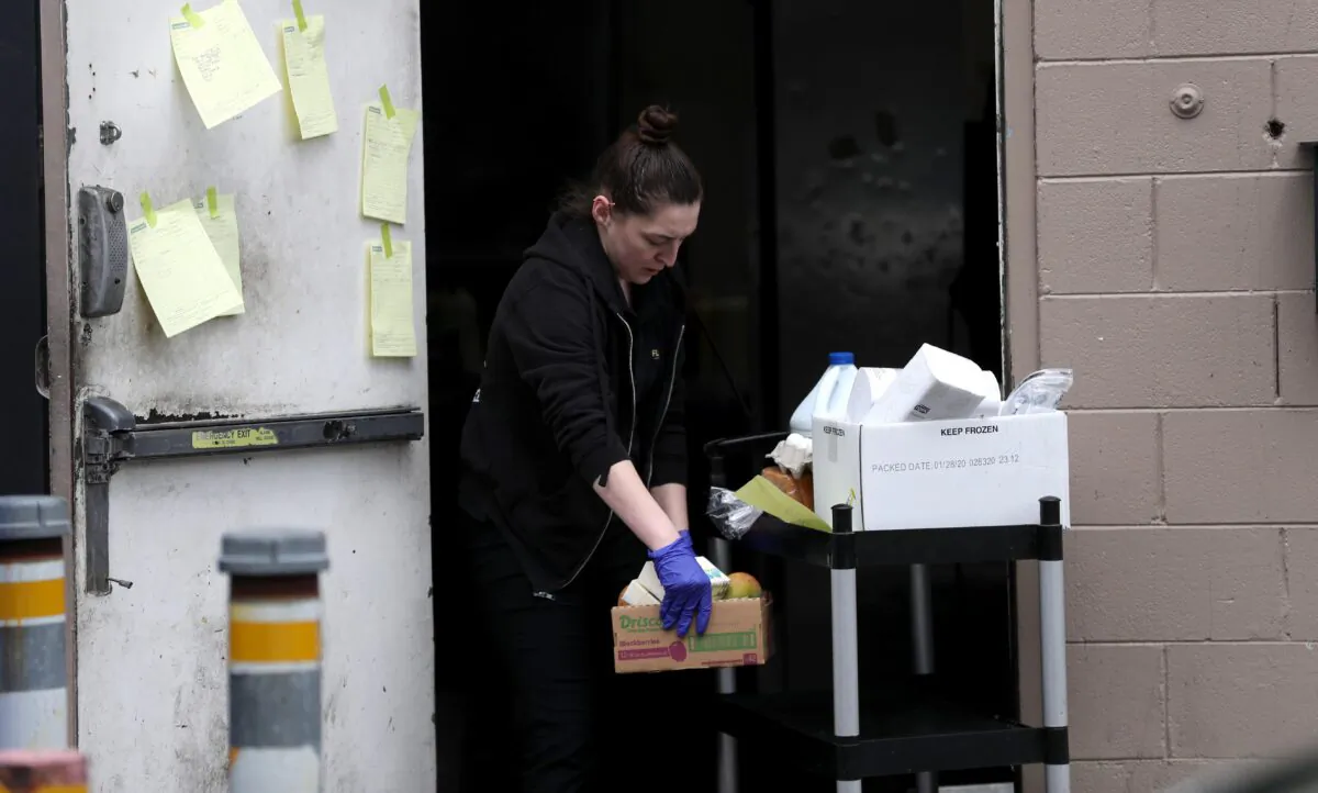 Maddy Dunn, a worker at Flights restaurant, fills orders during a drive thru no-touch groceries and to-go food service at the restaurant in Los Gatos, Calif., on March 23, 2020. (Justin Sullivan/Getty Images)
