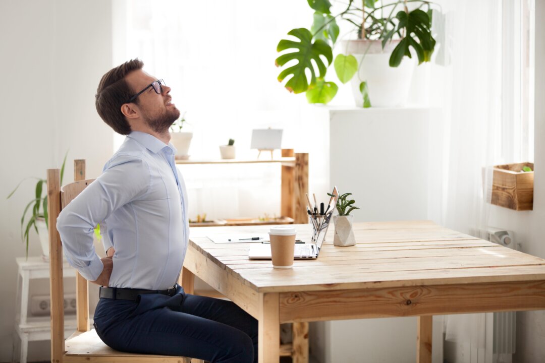Too much time hunched over devices can create strain on your body. (fizkes/Shutterstock)