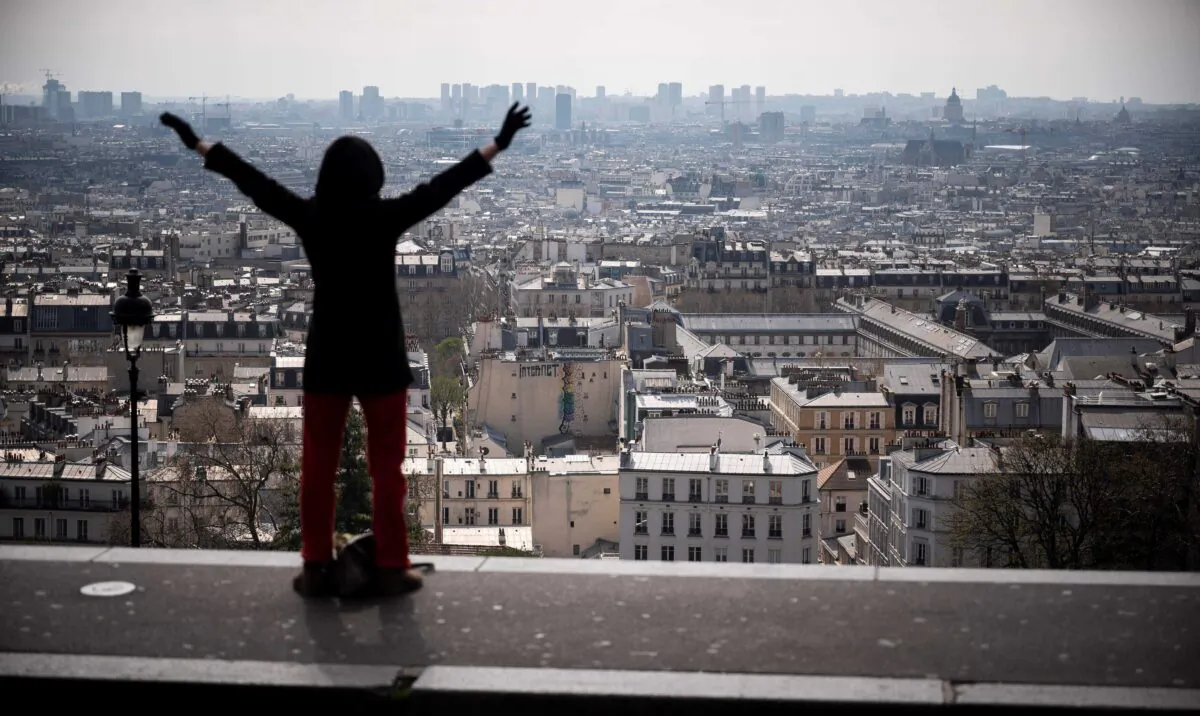 A woman stretches on top of the Montmartre hill neighbourhood of Paris on March 22, 2020, the sixth day of a strict nationwide confinement seeking to halt the spread of the CCP virus. (Lionel Bonaventure/AFP via Getty Images)