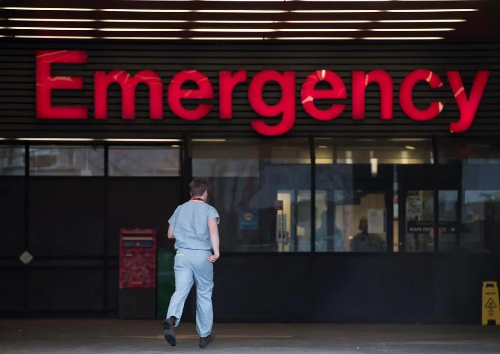 A health care worker is seen making his way into the Emergency dept. of the Vancouver General Hospital in a file photo. (Jonathan Hayward/The Canadian Press)