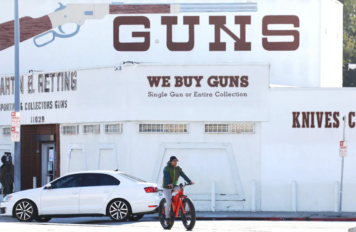 A cyclist rides past the Martin B. Retting gun store in Culver City, California, on March 24, 2020. (Mario Tama/Getty Images)